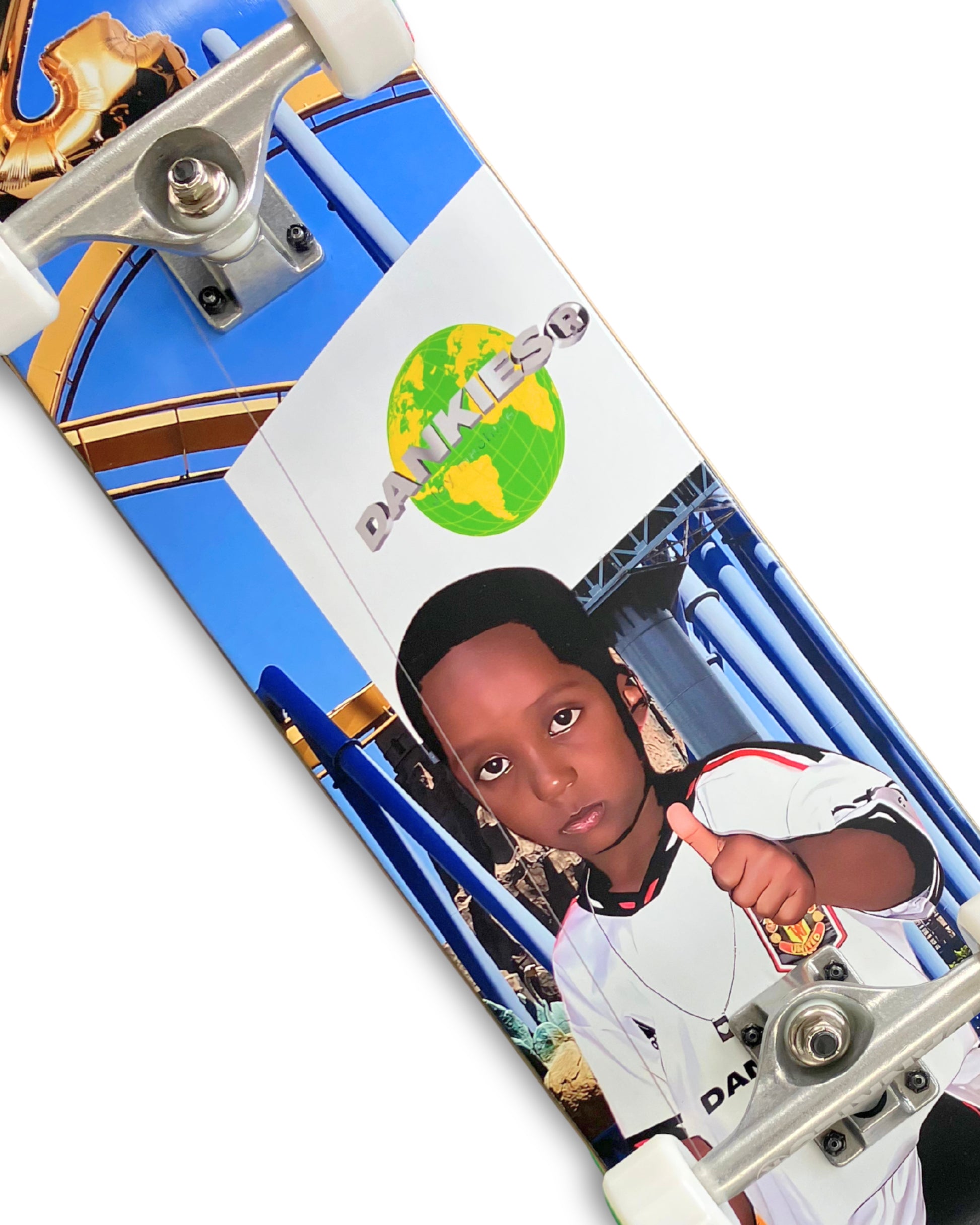 Dankies 4L Complete Skateboard with 4th Anniversary Graphic that features a kid holding a Number 4 balloon in a theme park - middle